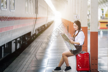 婴儿身着红色礼服并携带行李的亚洲妇女怀孕看火车站旅行铁路街道图片