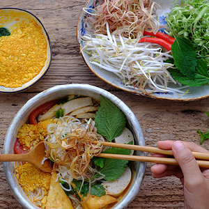 最佳顶端观赏人吃碗自制素食大菜面汤或螃蟹糊的维米切利汤这是越南传统菜盘准备以木本做饭包子人们图片