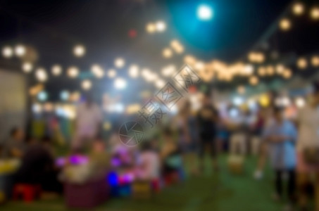 为背景使用而在街头夜间市场节上行走的抽象模糊不清的人生产文化派对图片
