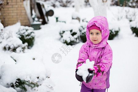 一种童年个快乐的孩子在冬日户外雕刻雪球冬季运动会一个快乐的孩子在冬日户外雕刻雪球坦率图片