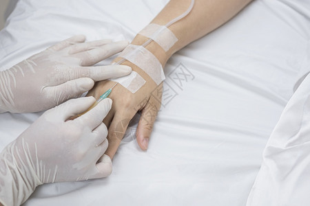 医生的高角度视手用注射器将盐水针入医院床上的女病人痛进入房间图片