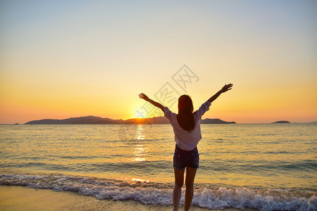 美丽的太阳黎明站在海边滩上的妇女在晚金时日落的背景下在泰国旅行暑假沙滩上站着图片