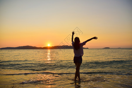 水夏天站在海边滩上的妇女在晚金时日落的背景下在泰国旅行暑假沙滩上站着裙子图片