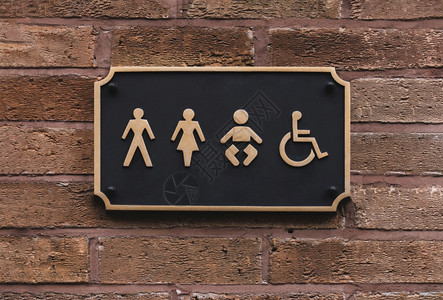 椅子在黑金和墙上挂着字母和框架的所有别卫生间标志WC公共卫生间标志上的厕所图砖墙上有一个男女儿童及残疾人符号绅士们图片