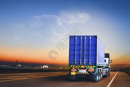 速度仓库载有集装箱的拖车在晚上高速驶往工业区的高速公路上行驶至工业区运输图片