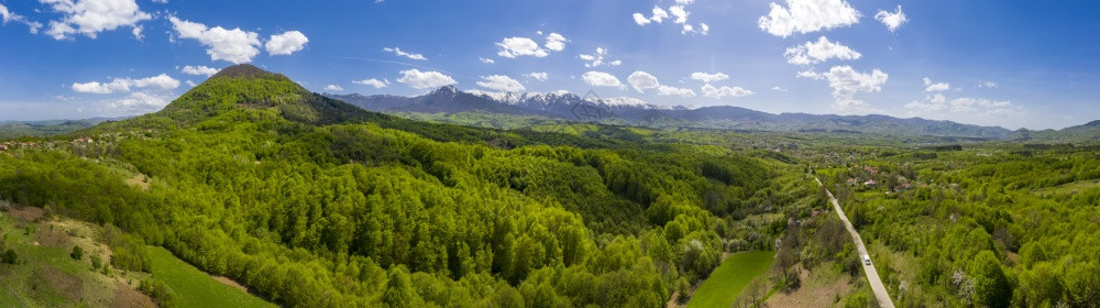 自然景观山腰上无人驾驶飞机的全天观春季有绿色山丘和道路图片