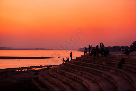闲暇老挝旅游者和人民放松了湄公河黄昏时的露台观景在湄公河万象老挝西尔维特上飞扬的夕阳天空反射城市户外图片