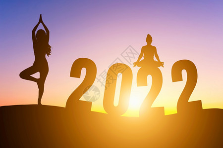 晚上新的年快乐20席丽休埃特女在清晨做瑜伽地平线背景健康与新年概念上日出象征图片