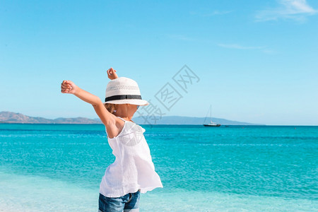 太阳沙滩上可爱的小女孩在暑假时海滩上可爱的小女孩在海边度假自然帽子图片