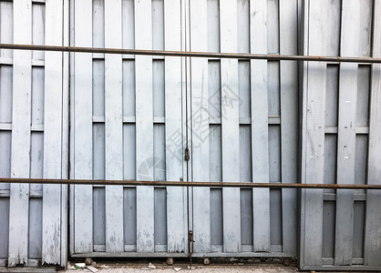 住宅锁在旧仓库金属铁轨上的旧木制门白色的陈年图片