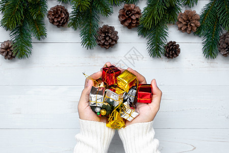 持有礼品盒圣诞装饰和木背景的松树枝节日概念准备新年快乐和Xmas假日顶端风景等礼物盒的妇女弓红色圣诞节图片