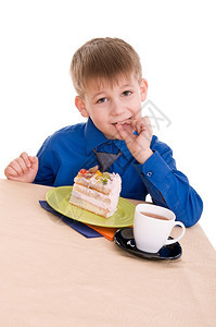 餐巾黄色的儿童在白背景上吃蛋糕时的肖像画生日图片