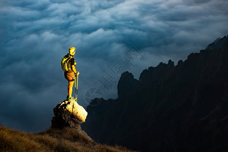 山上美丽的日落山上还有登者他到达的石头上最后一线阳光照着他来到的地方观察被云海包围的山谷轮廓半径岩石图片