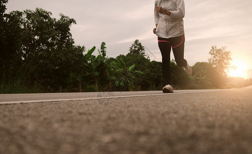 外部参加马拉松和健康生活方式概念Athlete在户外运动的员近腿的晨间培训在路上跑的女者踪迹关心图片
