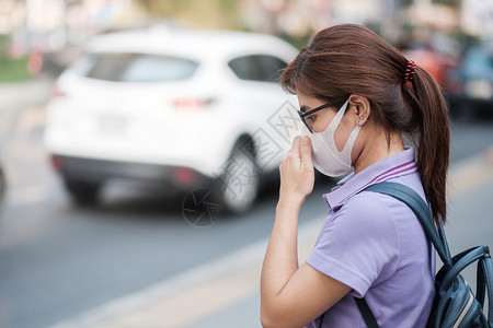 亚洲人空气质量穿戴N95呼吸面具的亚洲年轻妇女保护和过滤pm25微粒物质反对交通和灰尘城市保健及空气污染概念保护并过滤pm25颗图片