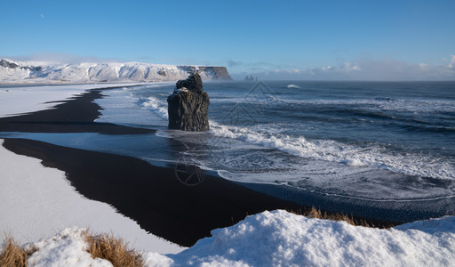 冰岛Dyrholaey角海岸景观的全图象在冬季与积雪覆盖海岸线的冰岛生物圈海景一种图片