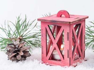 带蜡烛圣诞装饰品和树枝的木灯在雪地背景下有彩灯圣诞装饰和树枝木制的闪光蓝色图片