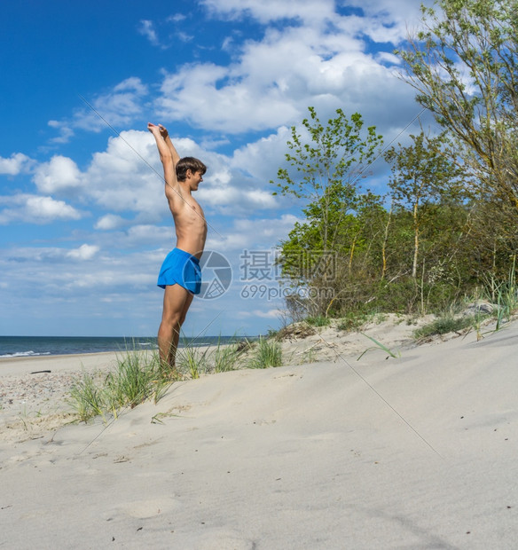 竞技加里宁格勒地区俄罗斯波的海20年6月日一名年轻运动员在海滩上进行体操课在滩上充电一名年轻运动员在海滩上体操课水锻炼图片