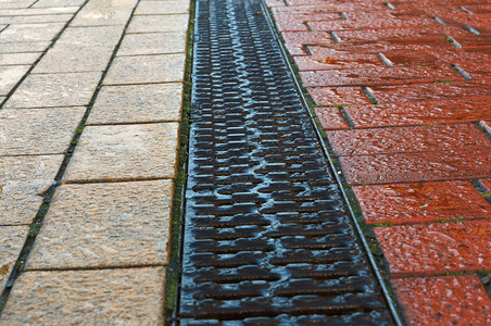 钛城市的排水沟铺红黄瓦人行道排水格栅是人行道上的雨水槽人行道排格栅是人行道上的雨水槽铺有红黄相间的瓷砖黑色图片
