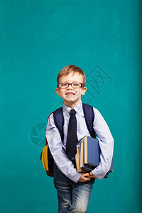 图书学校孩子拿着书的小学生快乐微笑的小孩背着大包靠在黑板上看着相机学校概念回到复制好的图片