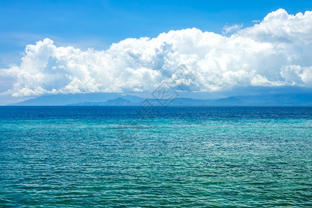 印度尼西亚的阳光日印度尼西亚的海松水平静洋的绿水远岸海平面上美丽云朵令人惊奇地异海平面上的风自然松弛目的地图片