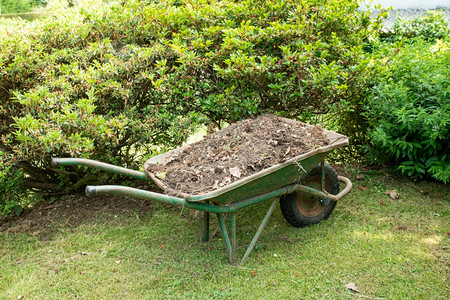 农业花园艺工具上填满土壤或堆肥的轮轴家关心背景图片