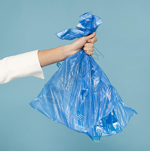 厨房拥有蓝色塑料垃圾袋的妇女高清晰度照片持有蓝色塑料垃圾袋的照片高质量品蓝色的常设图片