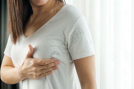 妇女用手检查胸腔上乳腺的肿块以发现乳腺癌症状妇女保健概念自己胸部组织背景图片