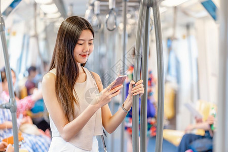 乘坐地铁看手机的年轻女孩高清图片