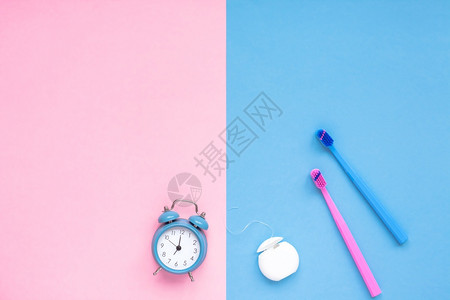 粉色的牙齿卫生和口腔科护理产品以及色粉和蓝背景复制空间警报钟的颜色粉和蓝时钟牙线和刷子的白管平板最顶层成像模拟早概念新鲜的管子图片