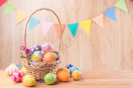 多色的横幅木制复活节快乐彩鸡蛋和木地板篮子中的鲜花模糊地用复制空间庆祝聚会旗帜图片