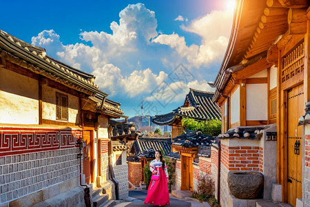 穿着韩国传统汉式建筑的漂亮女孩在韩国首尔KoreaBukchonHanok村传统韩国风格建筑城市传统的裙子图片