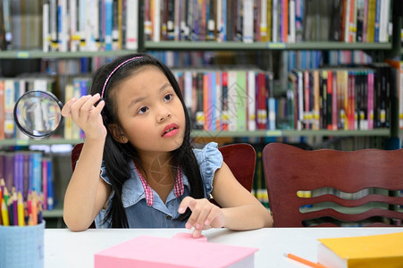 人们亚洲女孩在学校图书馆里拿着放大玻璃和思想的亚洲女孩教育和学习概念教育与学习概念明亮的使命图片
