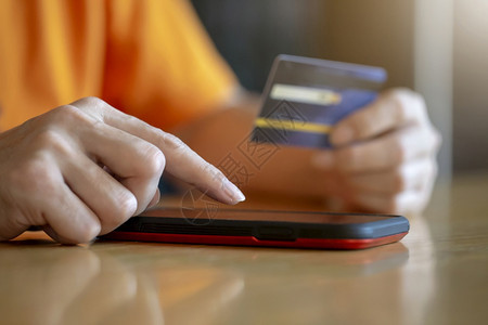 顾客展示以信用卡使移动智能手机的人商业电子务和应用概念来购买网上付款用信卡购物利移动智能电话的人技术图片