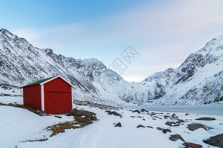 蓝色的斯堪纳维亚语岛上冬季的红木小屋挪威风格的红色礼服建造图片