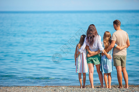 绿松石海岸线四口家庭在海滩度假时一起玩得开心年轻度假家庭玩得很开心爱图片