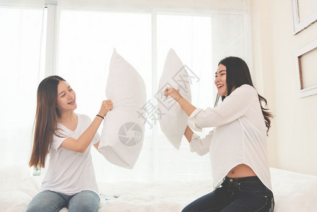 有趣的两个亚洲人在卧室做枕头搏斗生活方式和人与概念关系和友谊主题喜悦乐趣图片