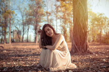 自然年轻的亚洲女人在秋天公园的摄像头面前摆姿势温暖的女孩图片