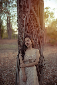 头发年轻的亚洲女人在秋天公园的摄像头面前摆姿势模型落下图片
