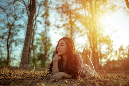 年轻的亚洲女人在秋天公园的摄像头面前摆姿势模型淑女自然图片