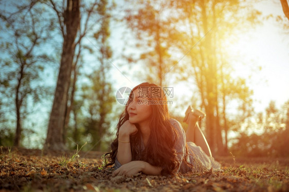 年轻的亚洲女人在秋天公园的摄像头面前摆姿势模型淑女自然图片