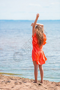 可爱快乐的小女孩日落时在海滩跳舞图片