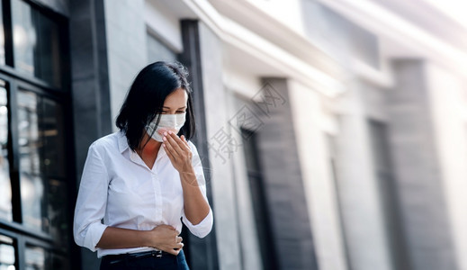 肺癌或科罗纳概念商业妇女在城镇市的传播中用医疗面具咳嗽女预防上市背景图片