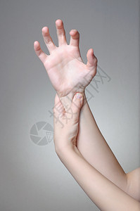 一位年轻女按摩她痛苦的手腕接触拉紧疼痛图片