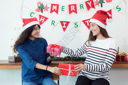 幸福亚洲人美丽的年轻女子在家里庆祝女人给他的朋友一个礼物盒克里斯玛概念图片