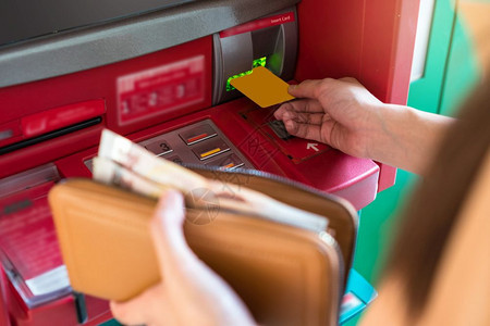 女士美元手特写人拿着钱包通过ATM取款商业自动柜员机概念图片