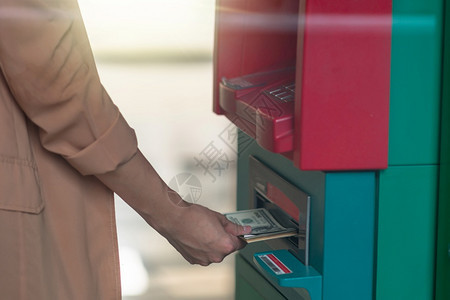 技术别针特写女人拿着钱包通过ATM取款商业自动柜员机概念的图片