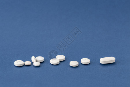 药店一种反抗蓝色背景上的不同白色药物蓝背景上的不同白色药丸图片