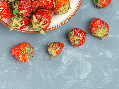 叶子新鲜的红草莓在盘子上新鲜的草莓在盘子上甜点素食主义者图片