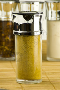 玻璃罐中的咖喱粉放在木垫上不同香料背景的玻璃罐中百里香一种美食图片